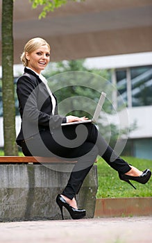 Beautiful business woman working with laptop in park