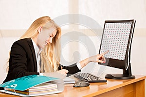 Beautiful business woman works in her office looks into monitro