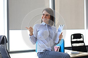 Beautiful businesswoman is expressing joyful in office while recieved good news