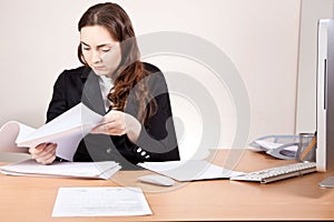 Beautiful businesswoman with financial reports at the office