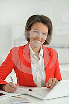 Beautiful businesswoman with laptop in her office