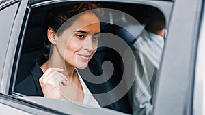 Beautiful businesswoman looking out of the window of a taxi
