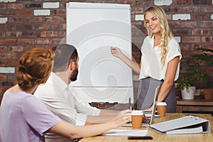 Beautiful businesswoman pointing towards whiteboard
