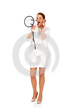 Beautiful businesswoman screaming through megaphone