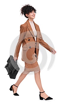 Beautiful businesswoman in suit with briefcase walking on white background