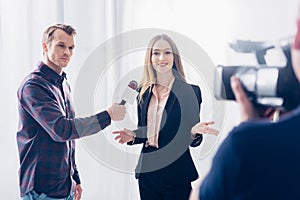 Beautiful businesswoman in suit giving interview to journalist and gesturing