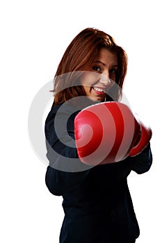 Beautiful businesswoman wearing boxing gloves punching