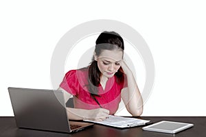 Beautiful businesswoman is writing on the clipboard