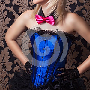 beautiful cabaret woman wearing fascinator, bow-tie and corset a