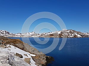 Beautiful calm blue ocean with mighty snowy island mountain range in the background on the Mageroy island, Finnmark, Norway
