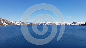 Beautiful calm blue ocean with mighty snowy island mountain range in the background on the Mageroy island, Finnmark, Norway