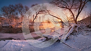 Beautiful calm evening on the small winter river, surrounded by overhanging trees. Winter landscape with a frozen river