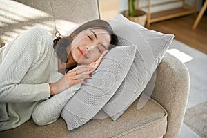 Beautiful, calm and peaceful Asian woman napping or sleeping on couch in her living room