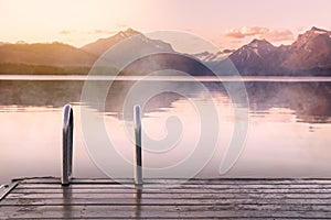 Beautiful calm peaceful scenic foggy lake and mountains view from wood decking, relaxation, tranquility, wanderlust