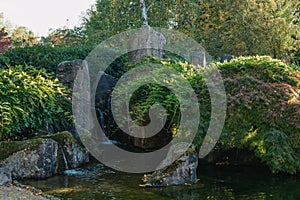 Beautiful calm scene with waterfall in spring Japanese garden. Japan autumn image. Beautiful Japanese garden with a pond