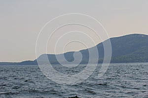 Beautiful calm seascape view with a faded mountain on the horizon