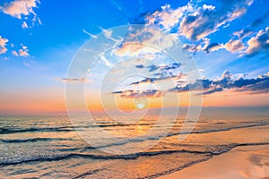 Beautiful calm sunset sky and fluffy clouds over the seascape