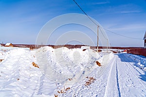 Beautiful calm winter rural landscape with brick house, snow in fields and road