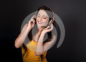 Beautiful calm young woman in yellow top listening the music in