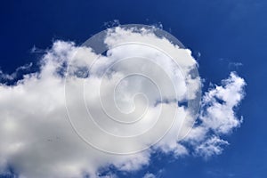 Beautiful calming fluffy white clouds in a deep blue summer sky