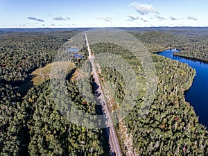 Beautiful Canada camper bus driving on road endless pine tree forest with lakes moor land aerial view travel background