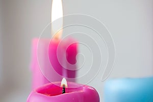 Beautiful candles stand near the window and the fire is burning. light festive background