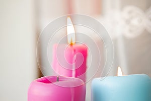 Beautiful candles stand near the window and the fire is burning. light festive background