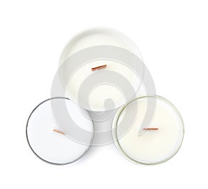 Beautiful candles with wooden wicks on white background, top view