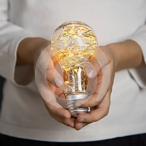 Decorative light bulb in the hands of a child