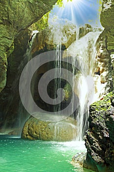 Beautiful caribbean jungle cave with waterfall, sun rays, natural water pool  - Somerset waterfalls, Portland, Jamaica focus on