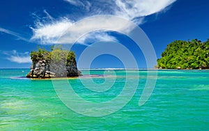 Beautiful caribbean landscape with secluded turquoise reef lagoon, rock, clear blue sky - Port Antonio, San San beach, Jamaica