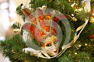 Beautiful carnival mask hanging on the Christmas tree in the background of bright Christmass decorations