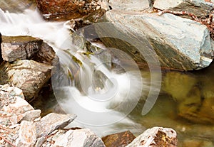 Beautiful cascade through mountain rocks