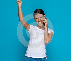 Beautiful casual woman celebrating succes and talking on the phone