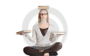 Beautiful casual woman sitting with books on palms and head, doing yoga.