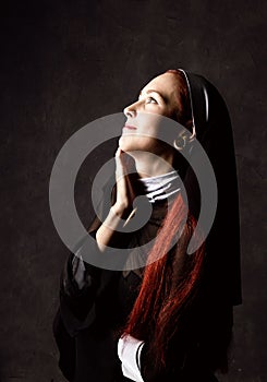 Beautiful catholic nun posing on a dark background. religious concept