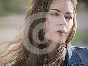 Beautiful caucasian brunette woman on a walk outdoors in park ne