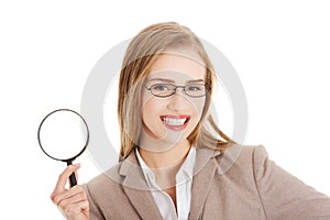 Beautiful caucasian business woman with magnifying glass.