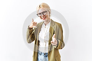 Beautiful caucasian business woman standing over isolated background smiling doing talking on the telephone gesture and pointing