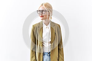 Beautiful caucasian business woman standing over isolated background smiling looking to the side and staring away thinking