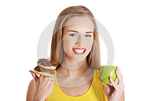 Beautiful caucasian casual woman with doughnuts and apple.