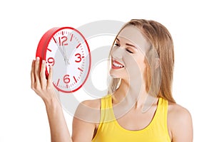 Beautiful caucasian casual woman holding red clock.