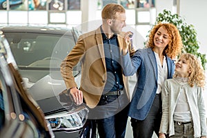 Beautiful caucasian family are owners of new car