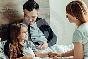 Beautiful caucasian family taking care of ill daughter