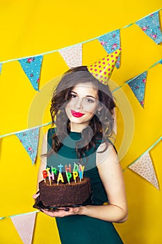 Beautiful caucasian girl blowing candles on her cake. Celebration and party.