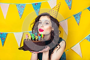 Beautiful caucasian girl blowing candles on her cake. Celebration and party.