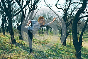 A beautiful caucasian girl doing yoga and sport outdoors. Early Spring in Eastern Europe.
