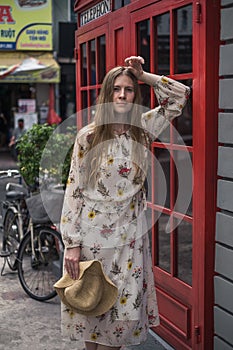 Beautiful caucasian girl in dress standing on the street in London.