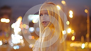 Beautiful caucasian girl fashion model walking in the night city, happy and smiling. A young woman with makeup in a