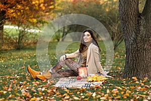Beautiful caucasian girl on the nature picnic with fruits. Relaxing young woman in Nature. Autumn landscape background
